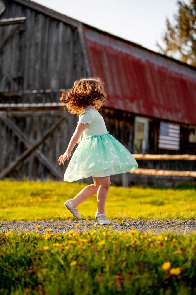 a little girl spins in a dress during a family photo session in Sullivan County NY