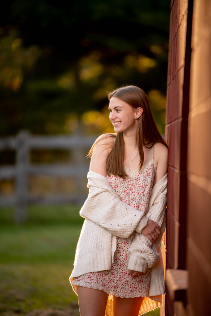 A high school senior leans against a building during a senior photo shoot in sullivan county ny