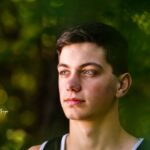 A high school senior looks off into the distance during a photo shoot