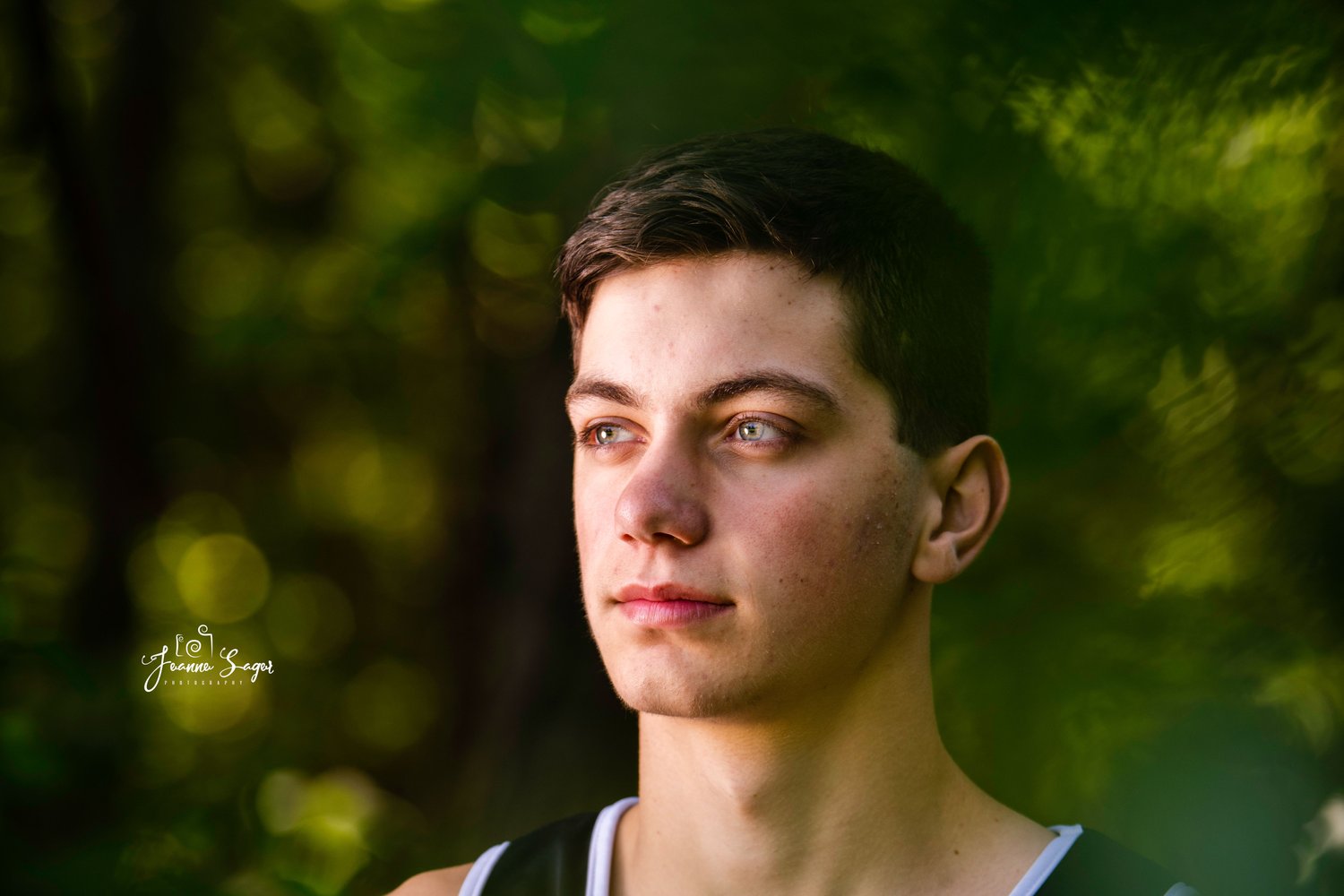 A high school senior looks off into the distance during a photo shoot