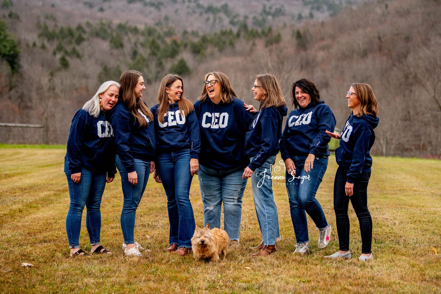 A group of 7 women are seen laughing during a branding photo session. Each is wearing a CEO sweatshirt.