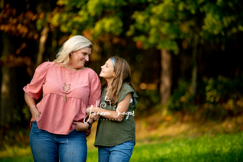 A mother and daughter smile at each other during a fall family photo session in callicoon ny